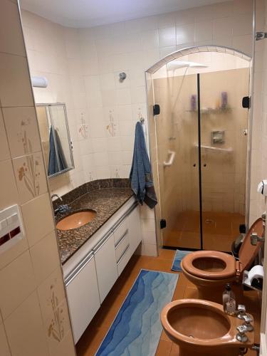ein Badezimmer mit 2 WCs und einer Dusche in der Unterkunft Las Brisas in São Vicente