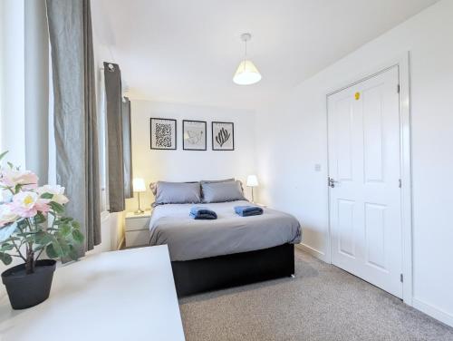 Guest Rooms Near City Centre & Anfield Free Parki في ليفربول: غرفة نوم بسرير في غرفة بيضاء