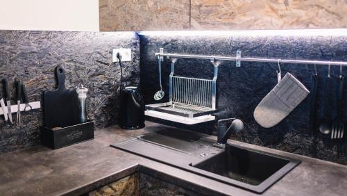 a kitchen counter with a sink and a kitchen utensils at Artistic Urban Retreat Olomouc in Olomouc