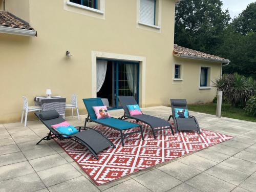 eine Sitzgruppe auf einem Teppich auf einer Terrasse in der Unterkunft Maison de vacances avec piscine in Chancelade