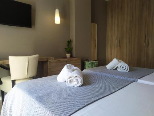 Dos toallas en dos camas en una habitación de hotel en Alpha Auriga Quiet Apartment, en Tirana