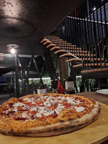 a pizza sitting on top of a wooden table at La Ruota Hotel Sharr in Dragash