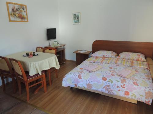 a bedroom with a bed and a table and a table and chair at Apartments and Rooms Tavcar in Bled