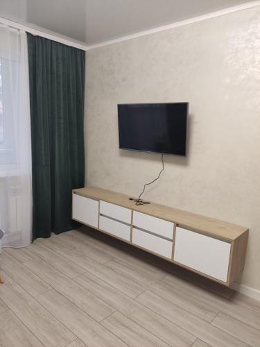 un soggiorno con una TV a schermo piatto su una parete di Apart.Botanica a Chişinău
