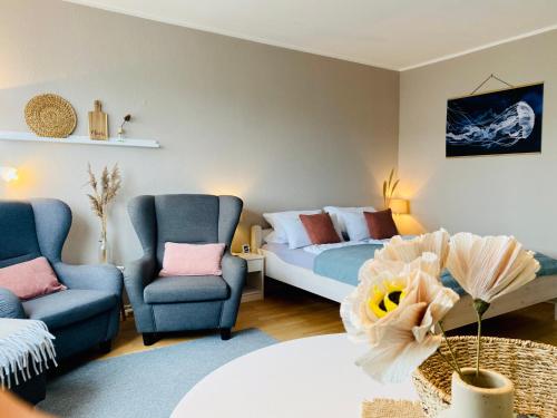 ein Wohnzimmer mit einem Bett und 2 Stühlen in der Unterkunft Ferienwohnung Meernähe in Fehmarn