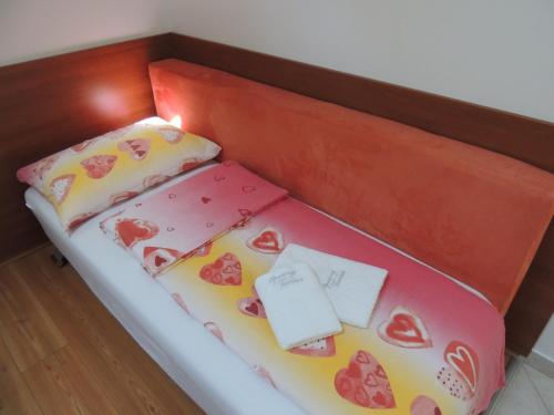 a bed in a box with hearts on it at Apartments and Rooms Tavcar in Bled