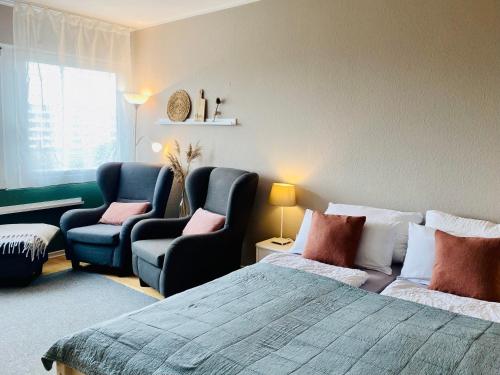 a bedroom with a bed and a couch and chairs at Ferienwohnung Meernähe in Fehmarn