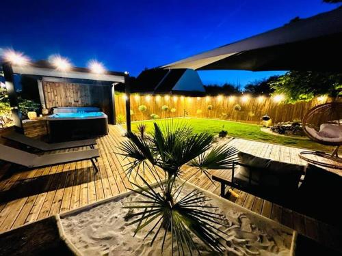 einen Hinterhof mit einem Pool und einem Zaun mit Licht in der Unterkunft KosyHouse - Un petit coin de paradis-SPA & Massage in Cauffry