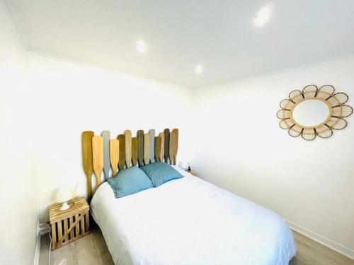 una camera da letto con un letto bianco e uno specchio a parete di KosyHouse - Un petit coin de paradis-SPA & Massage a Cauffry
