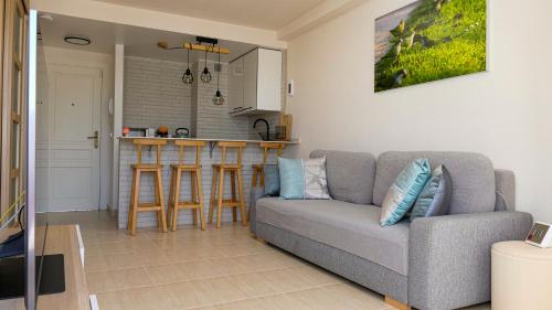 ein Wohnzimmer mit einem Sofa und einer Küche in der Unterkunft Belair Lloret Sun & Beach in Lloret de Mar