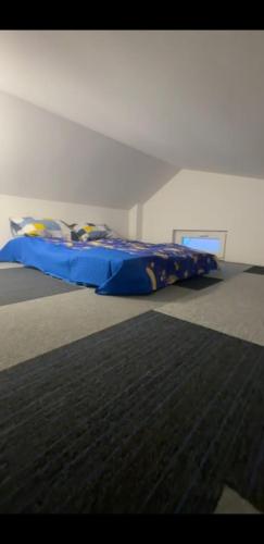 a bed with a blue comforter in a room at Apartman Cookie Kolačić blizu aerodroma Nikola Tesla in Dobanovci