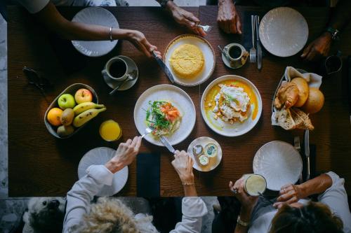 a group of people sitting around a table eating food at Boutique Hotel OLOM - Only Adults recommended in Cádiz