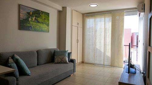 a living room with a couch and a sliding glass door at Belair Lloret Sun & Beach in Lloret de Mar