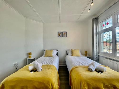 um quarto com 2 camas com lençóis amarelos em Great location, near M25 & A12 - Free Parking em Great Warley Street