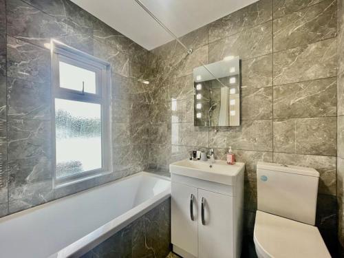 La salle de bains est pourvue d'une baignoire, d'un lavabo et de toilettes. dans l'établissement Great location, near M25 & A12 - Free Parking, à Great Warley Street