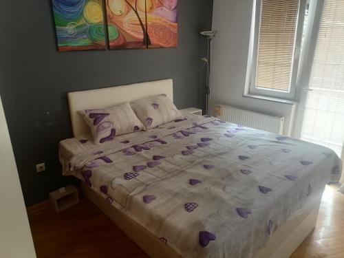 a bedroom with a bed with purple sheets and pillows at Dream S in Niš