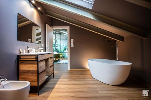 baño con bañera blanca grande y lavamanos en La Casa nel Parco luxury b&b, en San Lazzaro di Savena