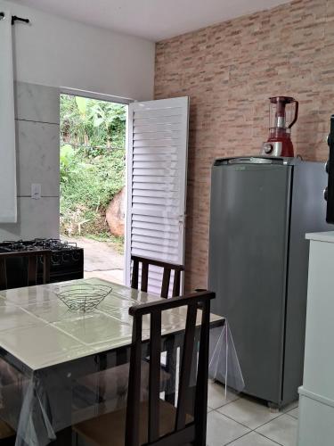 a kitchen with a table and a stainless steel refrigerator at AP número 3 in Governador Celso Ramos