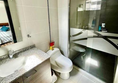 a bathroom with a toilet and a sink and a shower at SUITE PARQUE LA CAROLINA in Quito