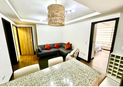 SUITE PARQUE LA CAROLINA في كيتو: غرفة معيشة مع أريكة وطاولة