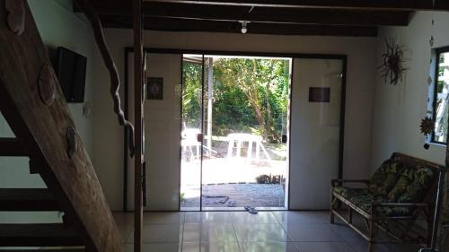 a living room with a door open to a patio at Chalé Encantadas Eco Ilha Preserve in Ilha do Mel