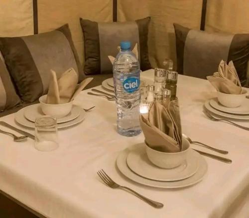 a table with plates and a bottle of water on it at Maria Sahara Camp in Merzouga