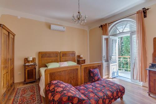 a bedroom with a bed and a chair and a window at Holiday home Villa Mare in Novi Vinodolski
