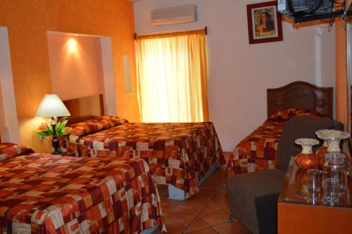 a hotel room with two beds and a window at Hotel La Rienda Mision Tequillan in Tequila