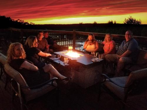 a group of people sitting around a table at sunset at Luxury getaway in woods, Jacuzzi, Hot Tub, Pool in Bushkill