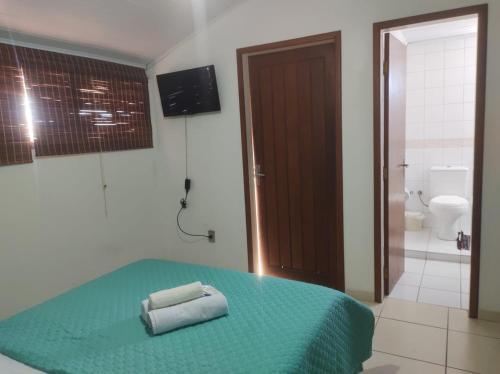 1 dormitorio con 1 cama con 2 toallas en Kata Hotel Boutique Floripa, en Florianópolis