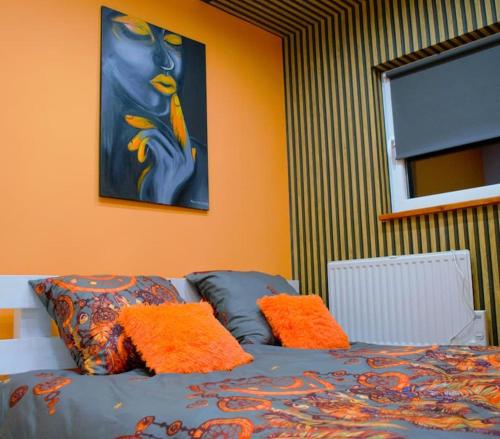 a bed with two orange pillows on top of it at Niesamowita Dolina 
