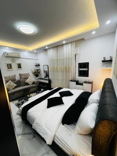 1 dormitorio con 1 cama grande y 1 sofá en شقة مفروشة بغرفتي نوم الجاردنز en Umm Uthainah