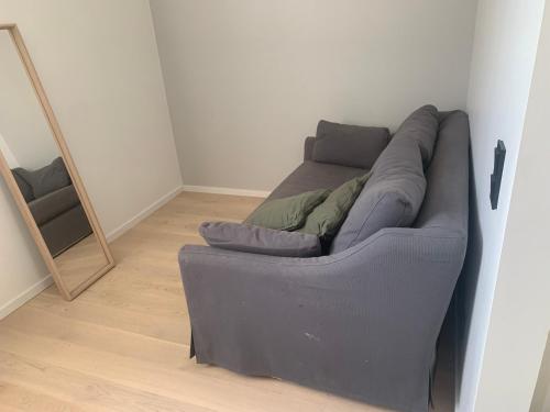 un divano in una stanza accanto a uno specchio di Apartment in Sollentuna 1109 a Sollentuna