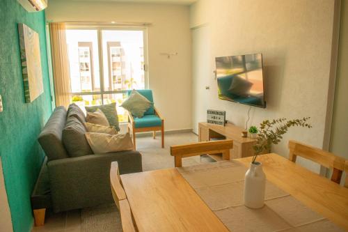 a living room with a couch and a table at Alberca, Playa Cercana & Club de Playa opcional -Departamento E13D302 in Gallinero