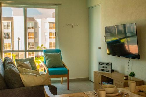 a living room with a couch and a large window at Alberca, Playa Cercana & Club de Playa opcional -Departamento E13D302 in Gallinero