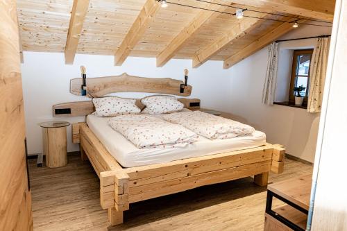 1 dormitorio con cama de madera en una habitación en Haus Kogelleiten, en Ramsau