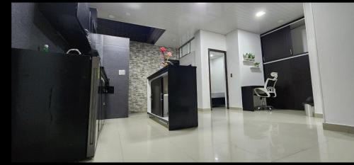 a living room with a chair in a room with black cabinets at Apartamento Moderno, Confortable y Central in Espinal
