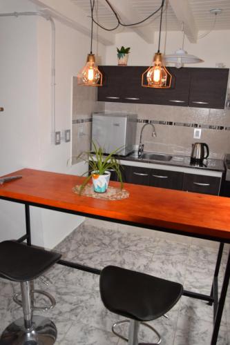 a kitchen with a wooden counter and two chairs at Tem Kotenkesh Depto Telenken x 2 pax in El Calafate