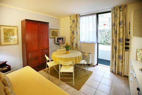 una camera con tavolo, sedie e finestra di Residence Gardasee 2 a Torri del Benaco