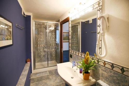 a blue bathroom with a sink and a shower at Residence Gardasee 2 in Torri del Benaco