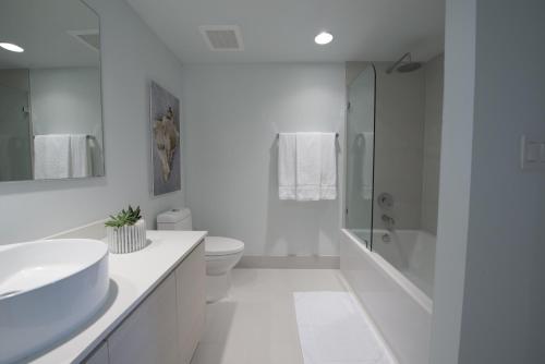 a white bathroom with a sink and a shower at Beachwalk Elite Hotels and Resorts in Hollywood