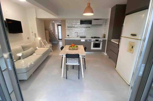 a kitchen and living room with a table and a couch at Urla Casa Bianca in Urla