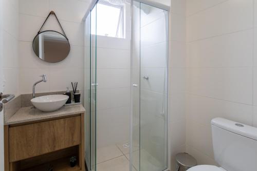a bathroom with a glass shower and a sink at Apartamento com VISTA MAR, Ar-condicionado, Wi-Fi Condomínio com PISCINA, quadra de esportes Playground infantil a 15 minutos do Beto Carreiro in Piçarras