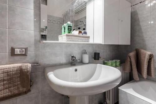 ミラノにあるMilanRentals - Baires Apartmentのバスルーム(白い洗面台、鏡付)