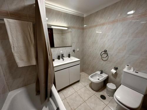 a bathroom with a toilet and a sink and a bath tub at SÃO GONÇALO APARTAMENTO in São Gonçalo