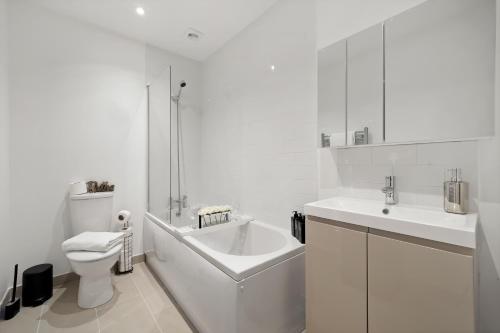y baño con bañera, aseo y lavamanos. en New Build 3 Bed House by AV Stays Short Lets Kent With Free Parking Ideal For Contractors en Sittingbourne