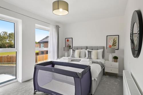 1 dormitorio con 1 cama y reloj en la pared en New Build 3 Bed House by AV Stays Short Lets Kent With Free Parking Ideal For Contractors en Sittingbourne