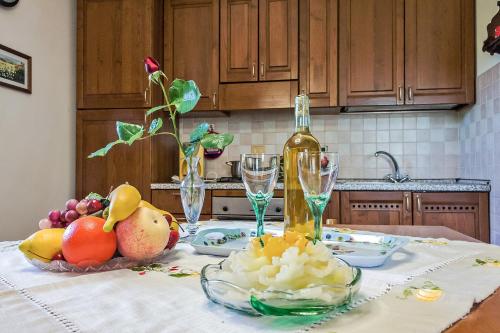 a table with a bowl of fruit and a bottle of wine at La Casanuova in Laiatico