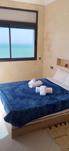 a bedroom with a bed with two towels on it at Amouage résidence 2 in Mirleft