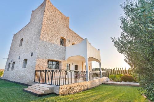 an external view of a large stone building with a fence at Maison Insa in Essaouira